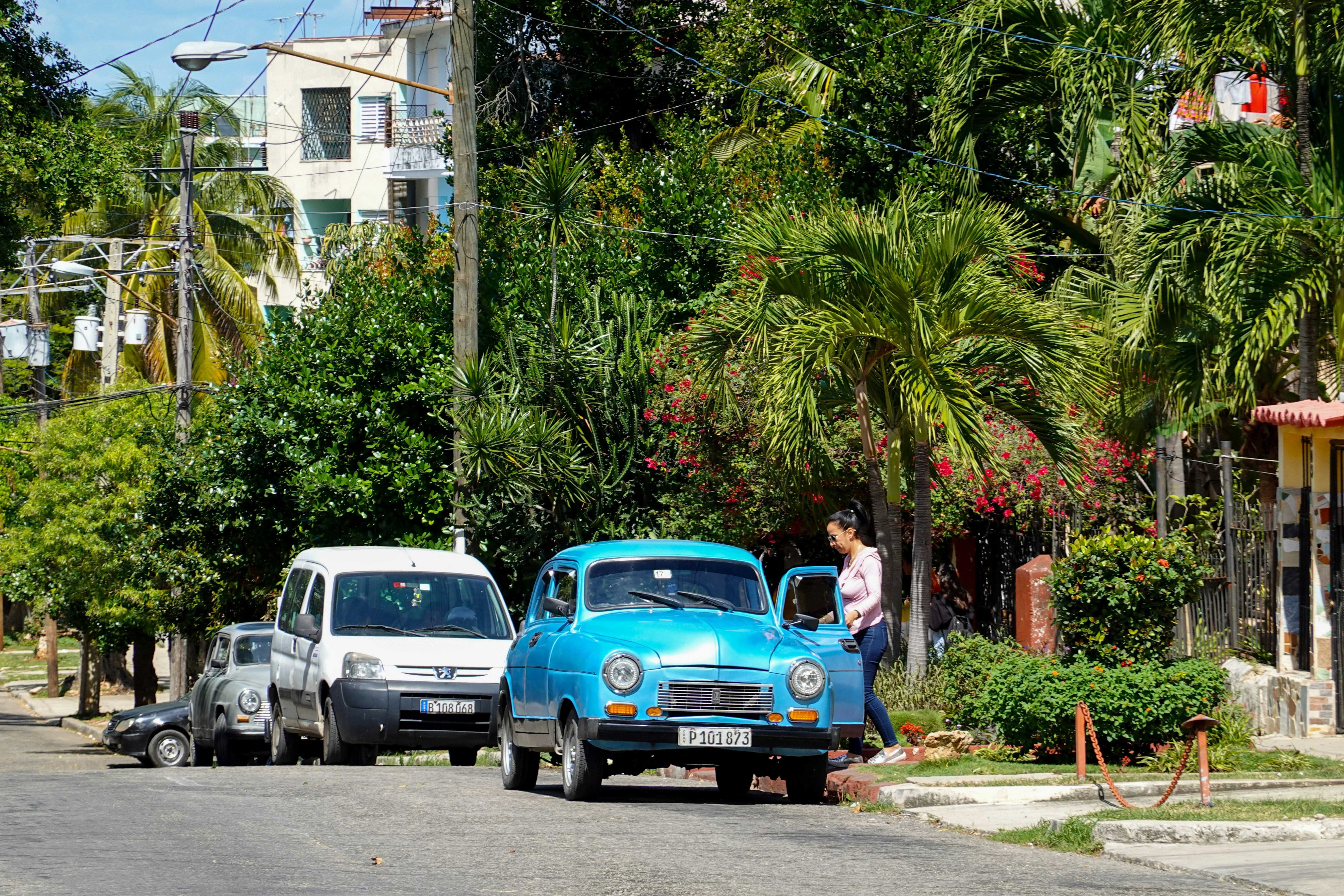 blue volkswagen beetle parked beside white car during daytime